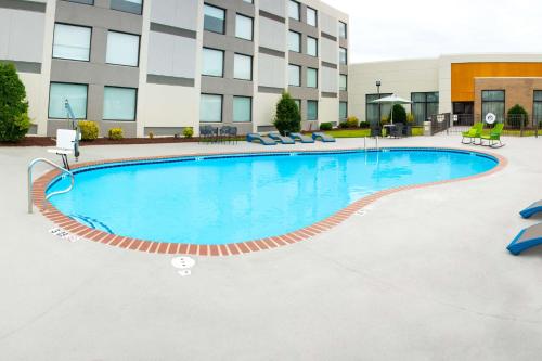 a pool in front of a building with a hotel at Hampton Inn Kinston in Kinston