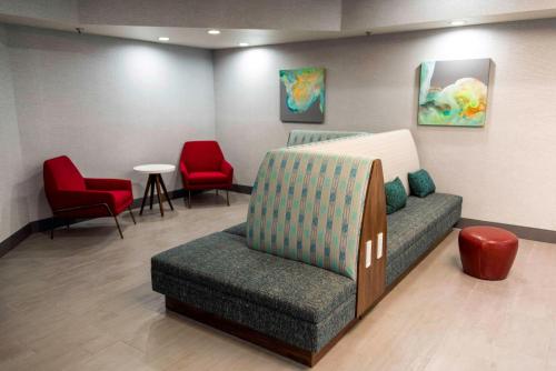 a waiting room with a couch and two red chairs at Hampton Inn Kinston in Kinston