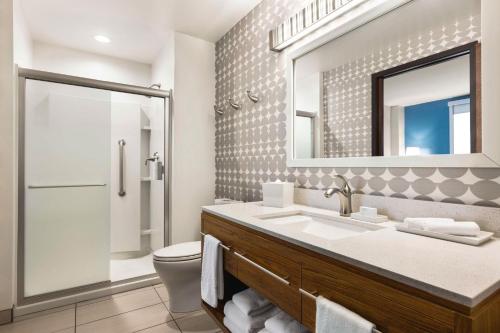 uma casa de banho com um WC, um lavatório e um espelho. em Home2 Suites Long Island City/Manhattan View em Queens