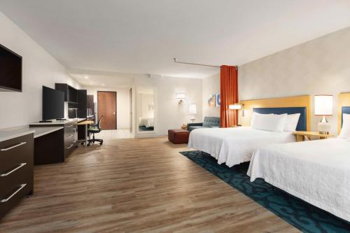 a hotel room with two beds and a television at Home2 Suites Long Island City/Manhattan View in Queens
