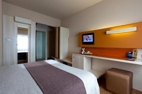a hotel room with a bed and a tv on the wall at Hotel Velino in Avezzano