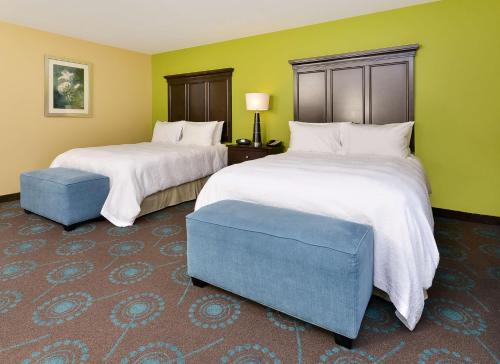 2 camas en una habitación con paredes verdes en Hampton Inn Iowa City/University Area, en Iowa City