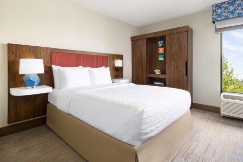 Hampton Inn Long Island/Islandia في ايسلانديا: غرفة نوم بسرير كبير ونافذة