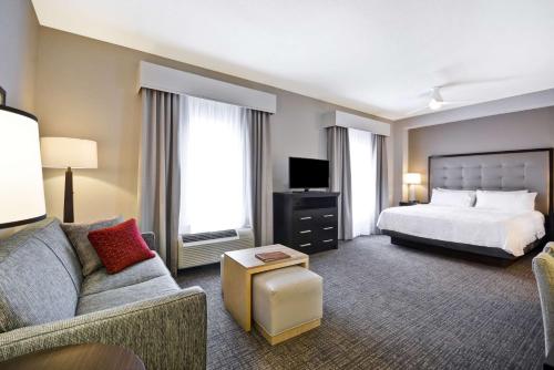 pokój hotelowy z łóżkiem i kanapą w obiekcie The Homewood Suites by Hilton Ithaca w mieście Ithaca