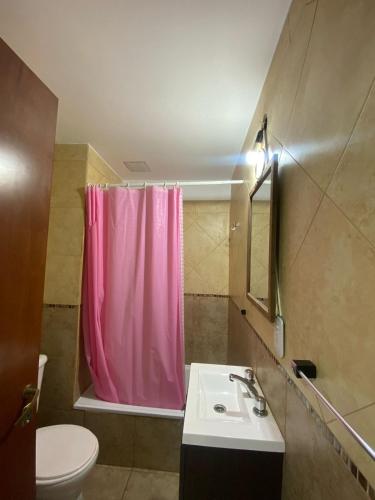 a bathroom with a pink shower curtain and a sink at temporarios en rosario in Rosario