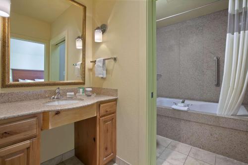 uma casa de banho com um lavatório, uma banheira e um espelho. em Homewood Suites by Hilton Jackson em Jackson