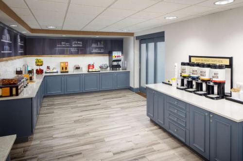 a coffee shop with blue cabinets and a counter at Hampton Inn by Hilton Garden City Long Island in Garden City