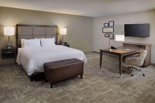 a hotel room with a bed and a desk and a computer at Hampton Inn by Hilton Garden City Long Island in Garden City