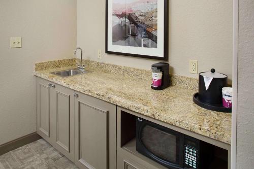 a kitchen counter with a microwave and a sink at Hampton Inn by Hilton Garden City Long Island in Garden City