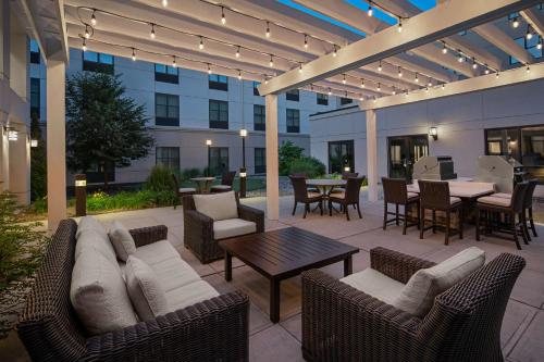 un patio con sofá, sillas y mesa en Homewood Suites by Hilton Carle Place - Garden City, NY, en Carle Place