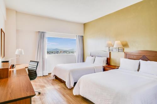 托雷翁的住宿－托雷翁加萊里亞斯聖日酒店，酒店客房设有两张床和窗户。