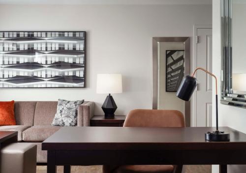 a living room with a couch and a table at Homewood Suites by Hilton Carle Place - Garden City, NY in Carle Place