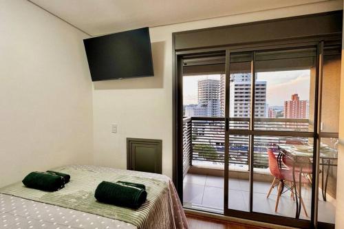 a bedroom with a bed and a balcony with a view at 717 - Rentaqui Studio Elegance Butanta in Sao Paulo