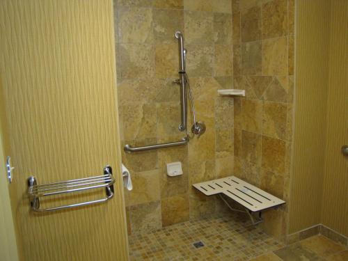 een badkamer met een douche en een bank. bij Hampton Inn & Suites Jamestown in Jamestown