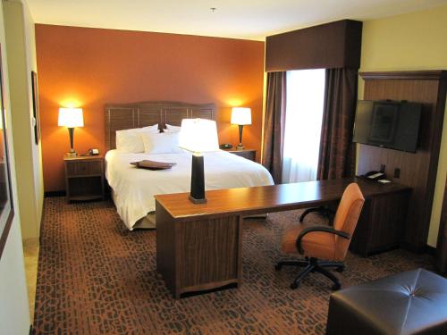 a hotel room with a bed and a desk with a desk at Hampton Inn & Suites Jamestown in Jamestown