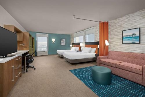 Habitación de hotel con cama y sofá en Home2 Suites by Hilton Jacksonville, NC en Jacksonville