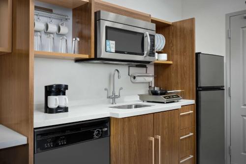 a kitchen with a sink and a microwave at Home2 Suites by Hilton Jacksonville, NC in Jacksonville