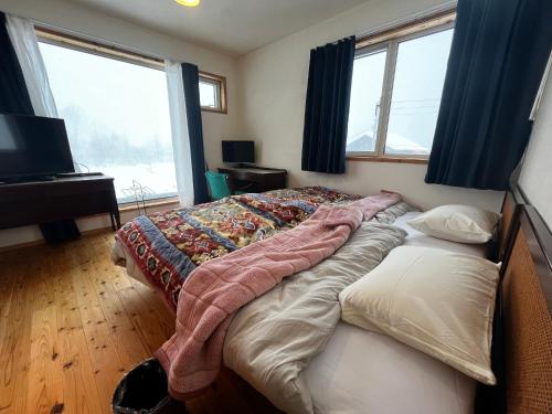 Un dormitorio con una cama con una manta. en Anaba Lodge, 
