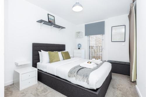 a bedroom with a large bed and a window at New 2BR wBalcony 1 min Ponders End Train, Enfield in Ponders End