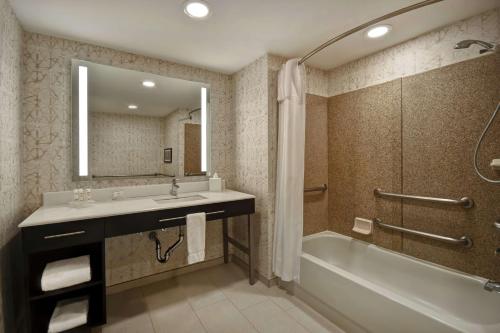 W łazience znajduje się umywalka, wanna i lustro. w obiekcie Homewood Suites by Hilton Edgewater-NYC Area w mieście Edgewater