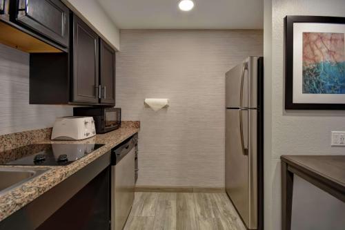 a small kitchen with a refrigerator and a sink at Homewood Suites by Hilton Edgewater-NYC Area in Edgewater
