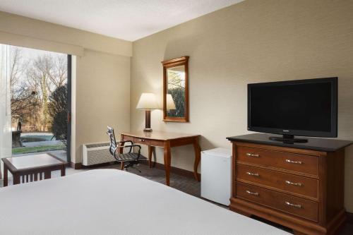 a hotel room with a bedroom with a television and a desk at DoubleTree by Hilton Hotel & Executive Meeting Center Somerset in Somerset