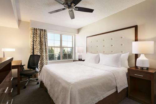 um quarto com uma cama, uma secretária e uma janela em Homewood Suites by Hilton Greensboro em Greensboro