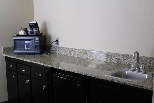 a kitchen counter with a microwave and a sink at DoubleTree by Hilton Springdale in Springdale