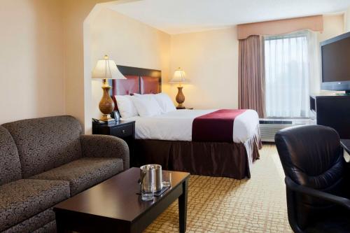 a hotel room with a bed and a couch at DoubleTree by Hilton Springdale in Springdale