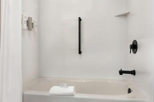 uma casa de banho branca com uma banheira e uma toalha em Hampton Inn & Suites Greenville-Downtown-Riverplace em Greenville