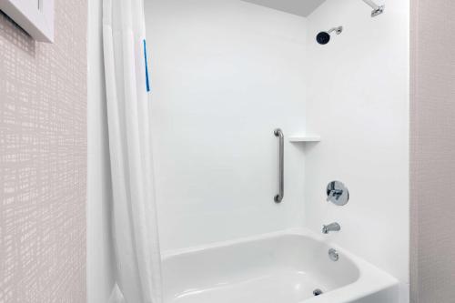 a white bathroom with a shower and a tub at Hampton Inn & Suites Fort Myers Beach/Sanibel Gateway in Fort Myers Beach