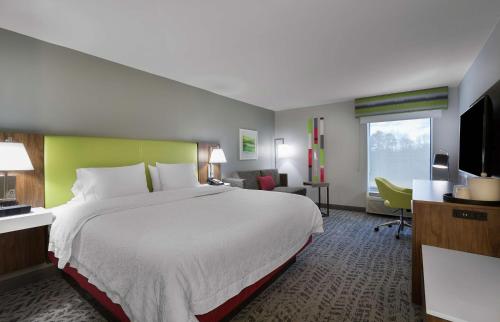 Habitación de hotel con cama grande y escritorio. en Hampton Inn Greenville/Travelers Rest en Travelers Rest