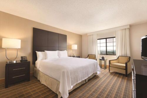 Pokój hotelowy z dużym łóżkiem i telewizorem w obiekcie Embassy Suites Greenville Golf Resort & Conference Center w mieście Greenville