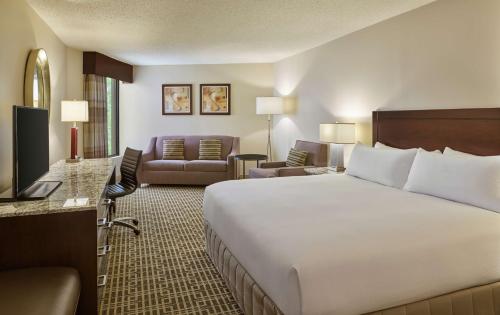 a hotel room with a large bed and a living room at DoubleTree by Hilton Houston Intercontinental Airport in Houston