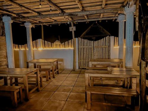 a room with wooden tables and benches in a building at Mi Casa en la Playa in Escuintla