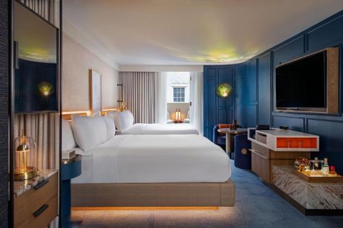 a hotel room with a large bed and a television at W New Orleans - French Quarter in New Orleans