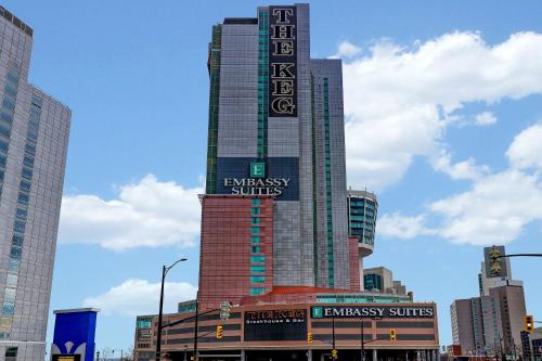 un edificio alto con un cartel en una ciudad en Embassy Suites by Hilton Niagara Falls/ Fallsview en Cataratas del Niágara