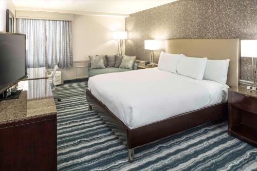 ウィルミントンにあるDoubleTree by Hilton Hotel Wilmingtonの大型ベッドとテレビが備わるホテルルームです。