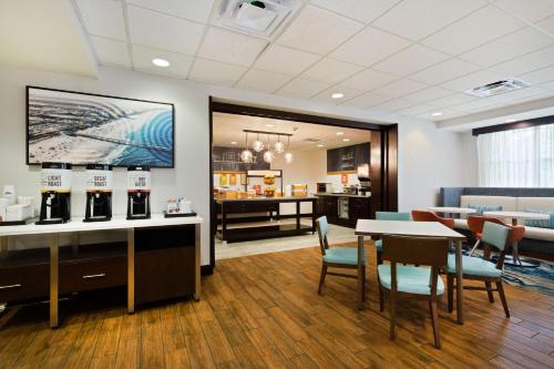 una sala d'attesa con tavolo e sedie di Hampton Inn Jacksonville-I-295 East/Baymeadows a Jacksonville