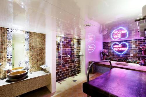 een paarse badkamer met een wastafel en een spiegel bij Amant Hotel in Goyang