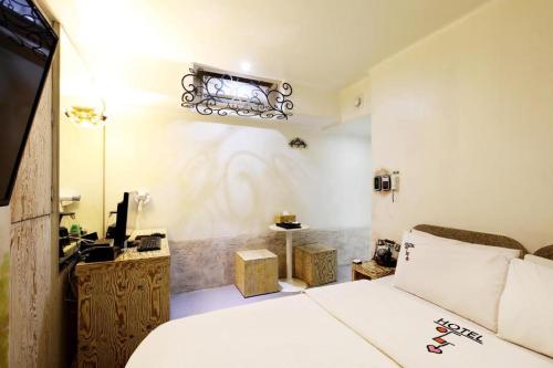 1 dormitorio con cama blanca y espejo en Amant Hotel, en Goyang