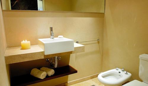 a bathroom with a sink and a toilet and a candle at Luxury 3 bedroom House in Palermo Viejo in Buenos Aires