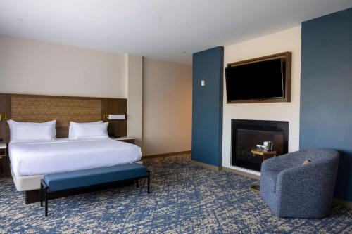 a hotel room with a bed and a fireplace at DoubleTree by Hilton Tinton Falls-Eatontown in Tinton Falls