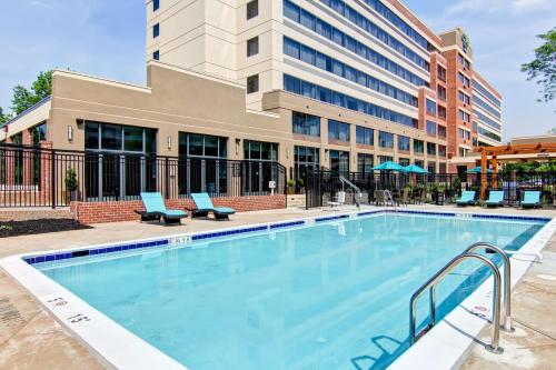 a swimming pool with a building in the background at Homewood Suites by Hilton Gaithersburg/Washington, DC North in Gaithersburg