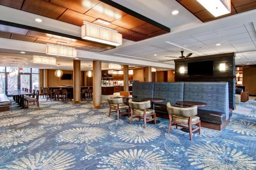 a lobby with tables and chairs and a television at Homewood Suites by Hilton Gaithersburg/Washington, DC North in Gaithersburg