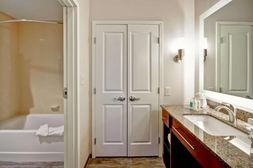 a bathroom with a white tub and a sink and a bath tubermott at Homewood Suites by Hilton Greeley in Greeley