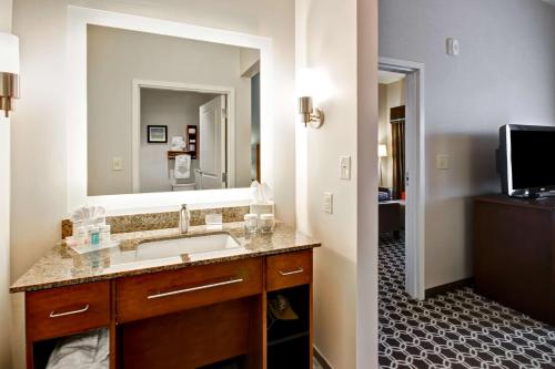 a bathroom with a sink and a large mirror at Homewood Suites by Hilton Greeley in Greeley