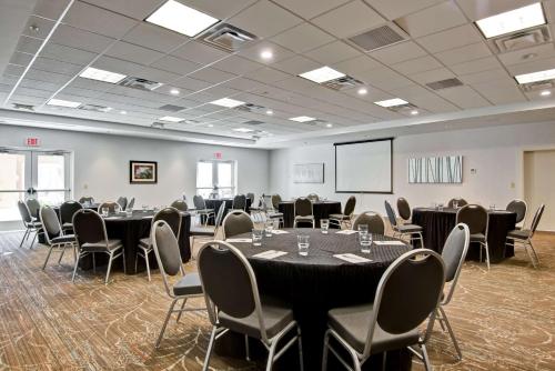 a conference room with tables and chairs and a screen at Homewood Suites by Hilton Greeley in Greeley