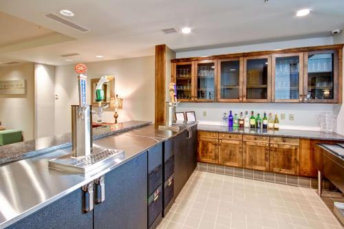 a large kitchen with wooden cabinets and a bar at Homewood Suites by Hilton Greeley in Greeley