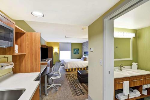 a hotel room with a bed and a bathroom at Home2 Suites by Hilton Idaho Falls in Idaho Falls